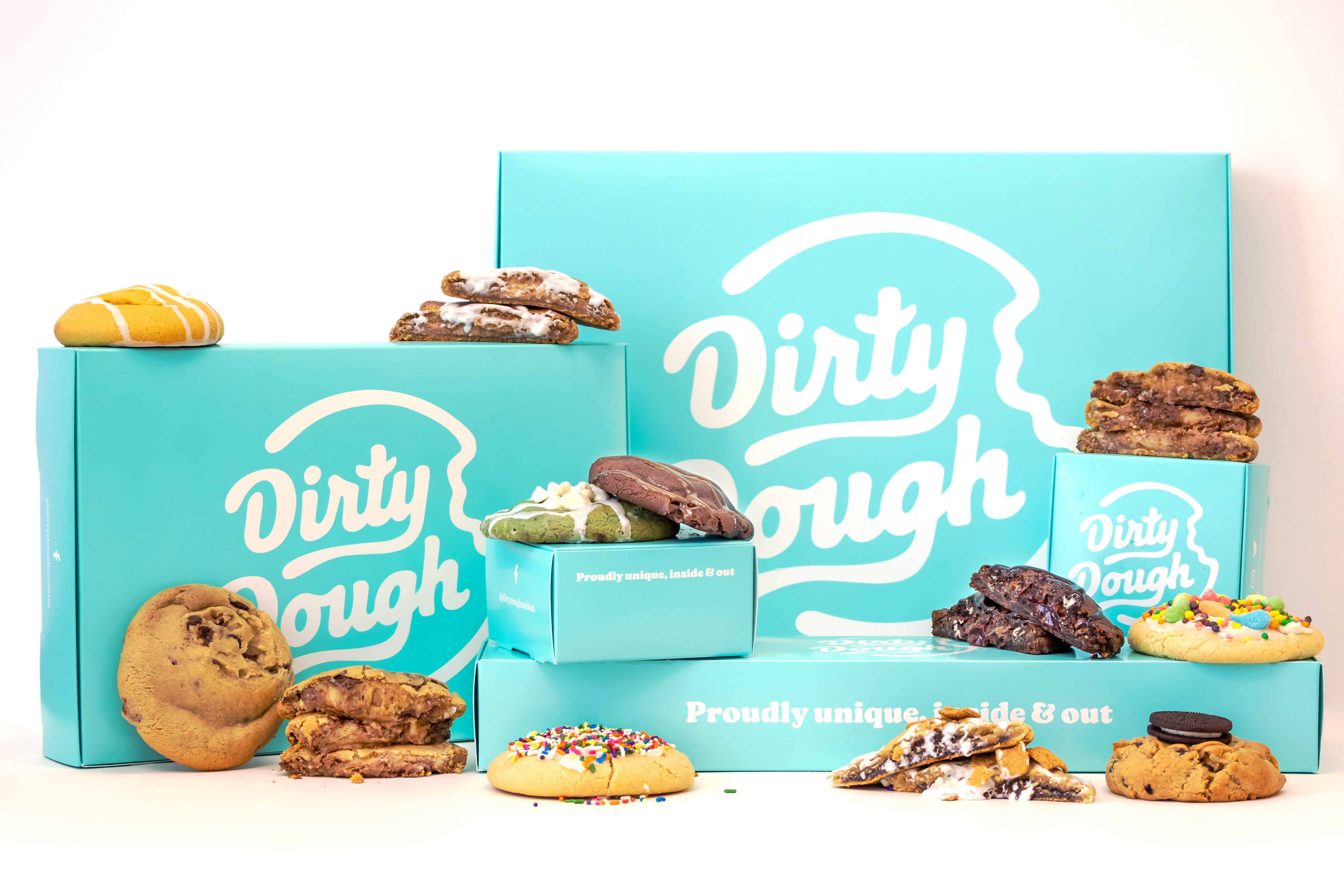 A variety of the rotating Dirty Dough cookies arranged in and around to-go boxes.